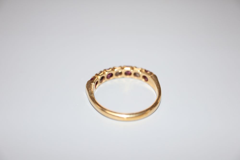 A modern 18ct, three stone diamond and four stone ruby set half hoop ring, size P/Q, gross 3.7 grams.
